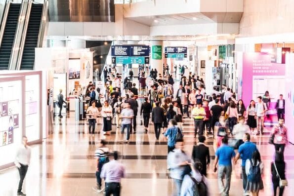4K UHD Time-lapse of crowded people at exhibition hall entrance. International tradeshow expo event, commercial trade activity, or business fair concept, zoom out effect
